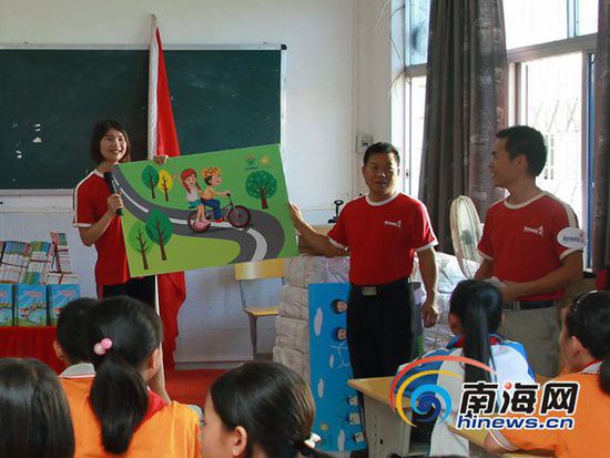 安利志愿者拿著KT畫板形象地告訴小學(xué)生自行車安全5守則