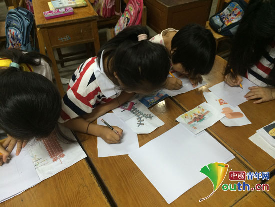 公益課堂上，鄭州大學支教團成員指導學生描繪河南景觀。