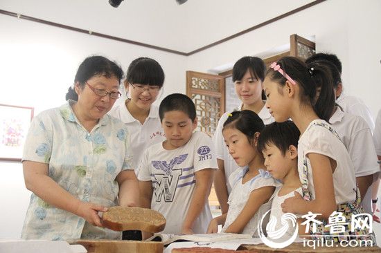 東昌府區(qū)年畫(huà)社社長(zhǎng)徐秀貞向同學(xué)們講解年畫(huà)制作過(guò)程。