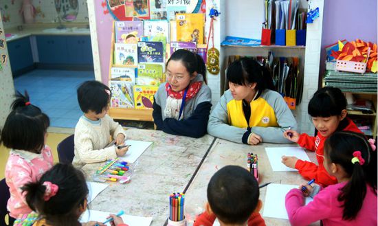 工美附中學生在輔導幼兒園小朋友學習繪畫