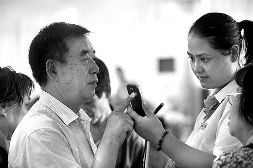 工作人員在教老人使用手機