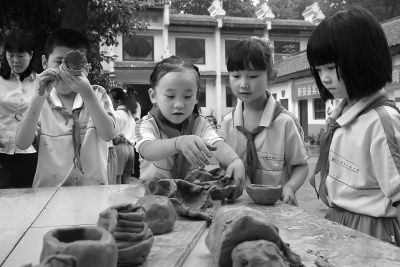 日前，新安縣實驗小學綜合實踐活動教育基地在洛陽志成新安窯體驗中心掛牌。新安縣是鈞瓷的發源地之一，洛陽新安志成酒器博物館的王志成館長，經過近十余年的潛心研究和技術攻關，新安鈞瓷茶具取得成功并推向市場。該基地有制作、陪燒設施，加之有酒器博物館和書法創作基地這些文化元素，讓學生們一下子來了興趣。圖為學生們在親手制作瓷器。