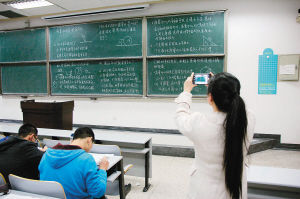 一位大學(xué)生下課后正在拍攝課堂板書