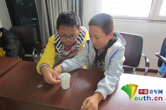 參加周末課堂活動的留守兒童在做“硬幣存水”科普實驗。哈爾濱工程大學支教團供圖 參加周末課堂活動的留守兒童在做“硬幣存水”科普實驗。哈爾濱工程大學支教團供圖